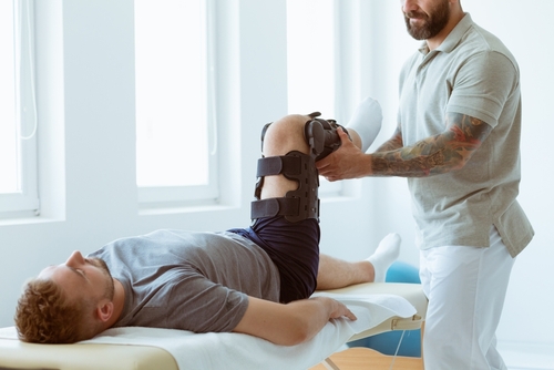 physiotherapist exercises in a bright medical office with his injured patient
